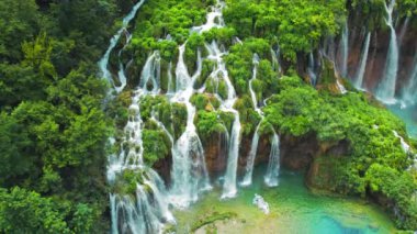 Tropik orman ve dağ manzarası. Su ve şelalelerden oluşan akarsular. İlkbahar ya da yaz aylarında şelaleler yemyeşil alanlar arasında akar. Plitvice Lakes Ulusal Parkı Hırvatistan. Seyahat ve doğa kavramı.