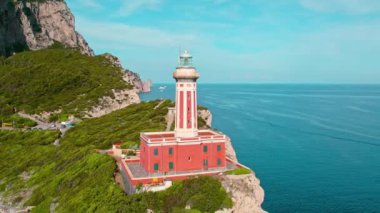 Deniz feneriyle kaplı Capri kıyı şeridine bakan güvenli geçiş sembolü olarak duruyor. Faro di Punta Carena 'nın İtalya' daki hava manzarası..