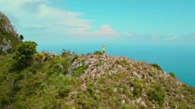 Rocky Zirvesi 'nden Solo Traveler Denizi Düşünüyor. Mavi denizin ve gökyüzünün engin genişliğine tepeden bakan, kıyı boyunca yürüyen yalnız bir kadın. Capri Adası, İtalya..
