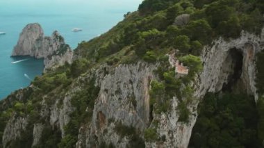 Heybetli uçurumlar sakin mavi deniz sularının üzerinde kule gibi. Capri Adası manzaralı, sakin okyanus manzaralı bir kadın. Yaz İtalya manzarası..
