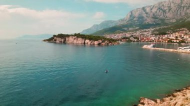 Hırvatistan 'daki Adriyatik Sahil Kasabası. Makarska Riviera, Adriatik 'in mavi denizi Biokovo dağını tamamlarken gün ışığında güneşleniyor..