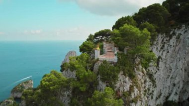 Capri Adası 'ndan Tyrhenian Denizi' ne bakan kadın. Kadın, yaz güneşli bir günde kayalık kıyıda meditasyon yapar. İtalya 'da doğayı izleyen bir kız...