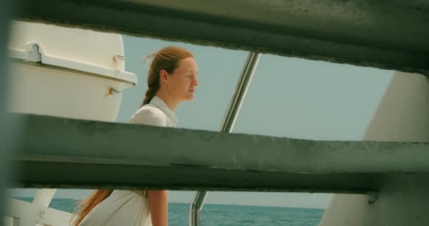 ある女性は晴れた日に船を造るために海を見つめている リラックスした姿勢で海風を楽しむトランキル観光客 夏休みについて — ストック動画