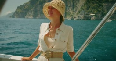 Bir kadın denize bakıyor, ikonik Positano kıyı şeridi nefes kesen bir arka plan oluşturuyor. İtalya 'da yaz tatili. Zevk teknesinden görüntü..