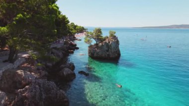 Hırvatistan 'ın Brela kentinde sakin atmosfer ve berrak deniz sularının havadan görünüşü ve cennet gibi yaz plajları.