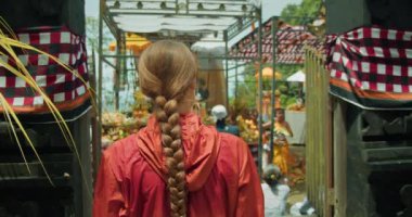 Kültürel döllenme, Bali 'deki tapınakta gösteri izleyen bir kadın. Bir gezgin geleneksel bir Bali dansını izler, arka planda yerel törenin şenlikli ruhu yer alır..