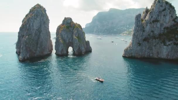 卡普里岛与标志性的海堆栈法拉格里奥尼从提尔尼海升起 在田园诗般的意大利水域中的游艇和小艇 — 图库视频影像