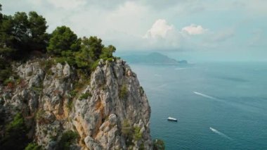 Capri kıyı şeridi, çarpıcı uçurumlar ve turistlerin bulunduğu lüks yatlar İtalya 'da denizde yelken açıyor. Dik kayalar okyanusun üzerinde kule...