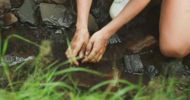 Kirli eller vahşi doğada temiz akarsu topluyor. Her damlasında tazelik. Ormana ağaç diktikten sonra kadın derede kollarını yıkıyor...