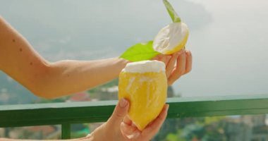Üzerinde krem şanti olan limonlu şerbet tutan bir kadın Amalfi Sahili 'nin güneşli manzarasına karşı koyuyor. Dondurma yalayan kız..