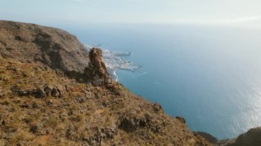 Kayalık kıyı kasabası Puerto Santiago ve derin mavi denize tepeden bakıyor. Tenerife 'nin engebeli kıyılarının havadan görünüşü..