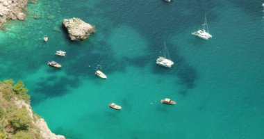 Tekneler, İtalya 'nın Capri kentindeki kayalık bir sahil şeridinde kristal berrak turkuaz deniz sularında yüzerek adanın güzel deniz ortamını gözler önüne seriyor...