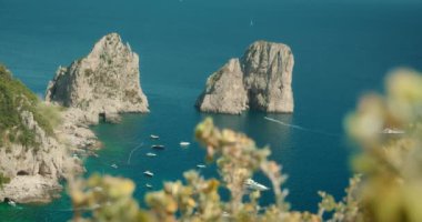 İtalya, Capri 'deki Faraglioni kaya oluşumları deniz ve teknelerin çarpıcı mavi sularını vurguluyor...