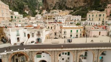 Bulutlu bir günde arka planda yemyeşil yamaçlı Atrani şehir binalarının yakın çekimleri.