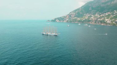 Sakin denizi noktalayan yelkenli gemi ve yatlarla Amalfi kıyı şeridinin havadan görüntüsü...