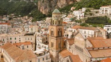 Önünde çan kulesi ve tepelerinde evleri olan Amalfi kasabası manzarası. İtalya 'da yaz tatili..