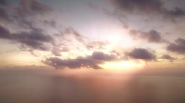 Gün batımında bulutlu gökyüzü okyanusun üzerinde ağır çekimde.