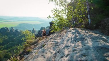 Yalnız bir yürüyüşçü kadın manzaranın köşesinde hareket ediyor, aşağıdaki vadinin nefes kesici manzarasını seyrediyor...