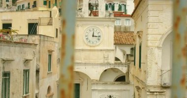 İtalya 'nın Atrani şehrindeki Amalfi Sahili' ndeki çan kulesindeki eski şehir saati, öğlen saatlerinde metal korkuluklardan izlendi..