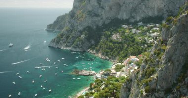 Marina Piccola 'da tekneli deniz manzarası ve Capri İtalya' daki kayalıklar ve binalar...