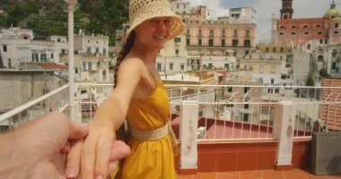 İtalya 'nın Atrani şehrindeki terasta eli önde olan genç bir kadın..