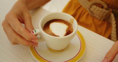 İtalyan kasabasında açık kafe masasında köpüklü bir fincan espresso..