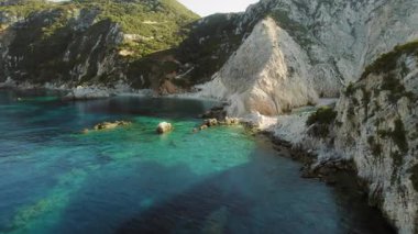 Turkuaz körfezi yazın Kefalonia adasında beyaz kayalıklarla ve yeşil tepelerle çevrilidir..