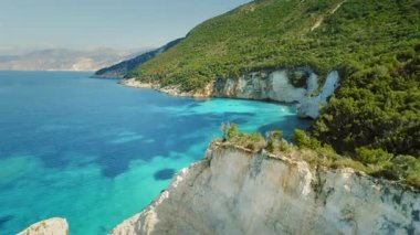 Kefalonia 'da bulunan yemyeşil kayalıklar ve canlı mavi körfez..
