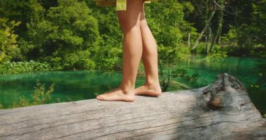 Hırvatistan 'daki Plitvice Gölleri Ulusal Parkı' nda turkuaz suyun üzerinde çırılçıplak duran kadın.