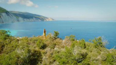Yunanistan 'ın Kefalonia adasındaki mavi İyon Denizi kayalıklarının keyfini çıkaran bir gezgin.
