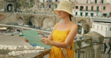 İtalya 'nın Atrani şehrinde deniz kenarında harita okuyan kadın..