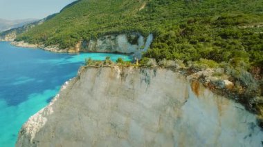 Yaz boyunca Yunanistan 'ın Kefalonia kentindeki turkuaz denizin üzerindeki yüksek bir uçurumun keyfini çıkaran çift.