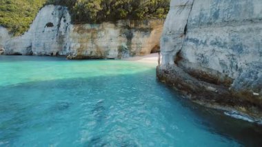 Beyaz Kayalıklar Sahilinde Turkuaz sulara atlayan kadın İyon Adası Yunanistan.