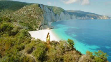 Kefalonya 'da mavi suları olan Fteri Sahili' ne bakan bir uçurumda duran turist.