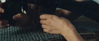 Eğitmen, silah taşıma eğitimi sırasında dışarıda atış dersi sırasında kadınların eline tüfek takmasına rehberlik eder..