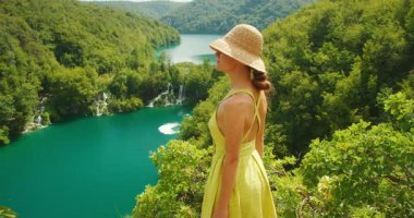 Hırvatistan 'daki Plitvice Gölleri Ulusal Parkı' nda mavi şelaleler üzerinde yüksek bir bakış açısına sahip olan kadın.