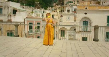 Atrani kasabası Amalfi sahilindeki tarihi binalarla dolu terasa limon atan kadın..