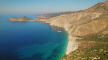 Kefalonia 'nın kayalıkları ve kıyıları sabah güneşinin altında sakin turkuaz denizle parıldıyor..