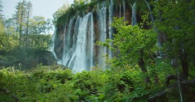 Hırvatistan 'ın yaz aylarında Plitvice Ulusal Parkı' ndaki açık bir göle büyük bir şelale düşüyor.