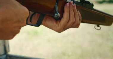 Atış talimi sırasında dışarıda sürgülü tüfeği hedef alan kadın..