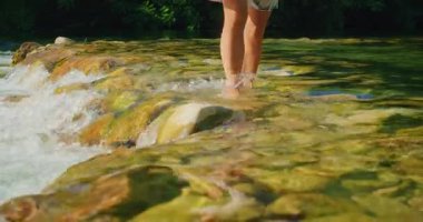 Hırvatistan 'da yaz aylarında Cetina Nehri' nin sığ kayalık akıntısını geçen kişi.