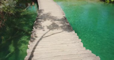Göl kenarındaki Plitvice Gölleri Ulusal Parkı Yazı Hırvatistan 'ın canlı yeşilliklerinden geçen yol.