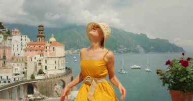 İtalya 'da yaz günü Atrani şehrinin manzaralı arka planında bir kadın poz veriyor..