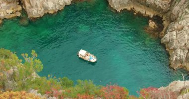 Kayalık zümrüt bir körfezde seyreden tekne yaz Capri 'sinde kayalıklarla çevrili..