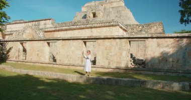 Yucatan Meksika 'daki arkeoloji sahasında taş piramit yapısını çeken bir turist..