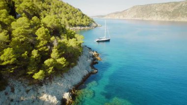 Yelkenli Kefalonia 'daki çam ormanları kayalıklarının yakınına demir attı..