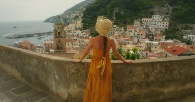 Katedral çan kulesi ve kasaba binalarıyla Amalfi Sahili 'ne bakan kadın..