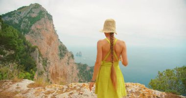 Capri 'deki bir yaz gezisi sırasında sahil manzaralı bir yerde telefonla gezen bir gezgin..