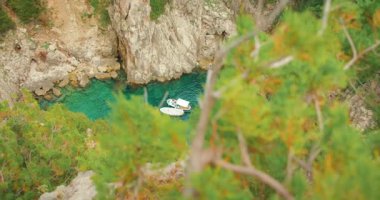 Capri 'deki kayalık kayalıklarla çevrili turkuaz koyda demirli küçük tekneler..