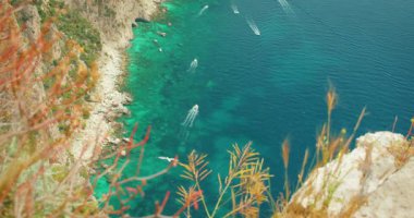 Capri Adası 'nda yaz mevsiminde dalgalı mavi denizde yüzen tekne ve yatlar..